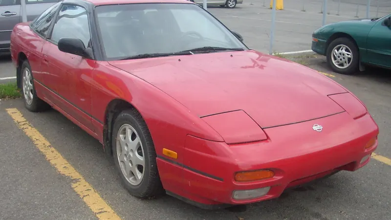 Photo of a Nissan 240SX fastback (S13, post-facelift), red, an example of the Nissan 240SX (S13, 1989-1994)